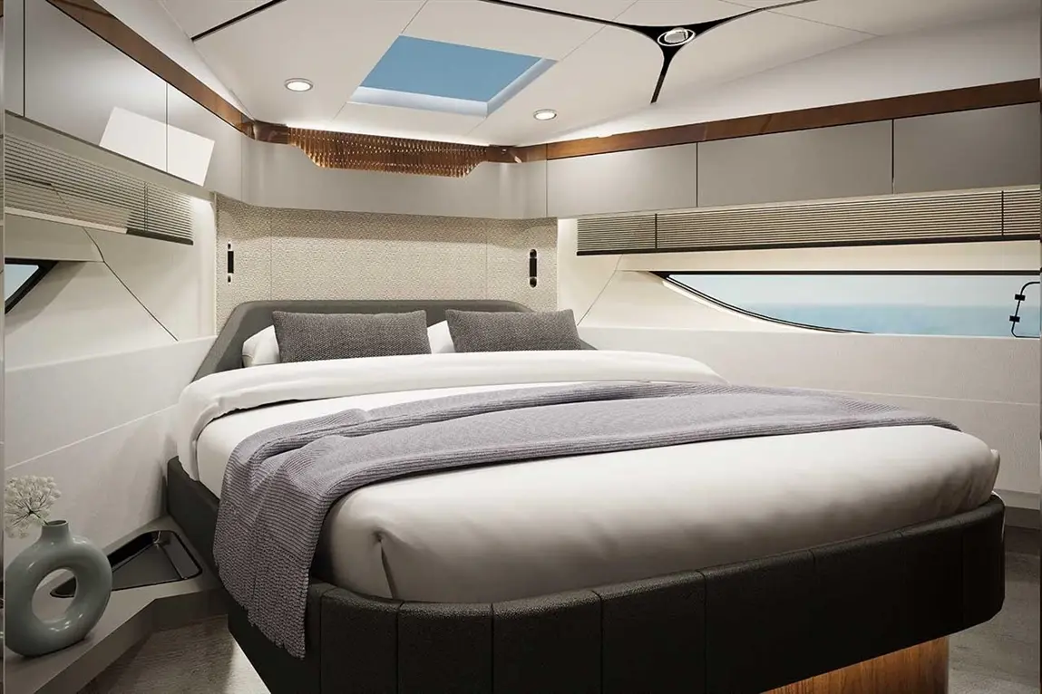 Modern cabin interior featuring a double bed with grey bedding, decorative pillows, and a skylight above.
