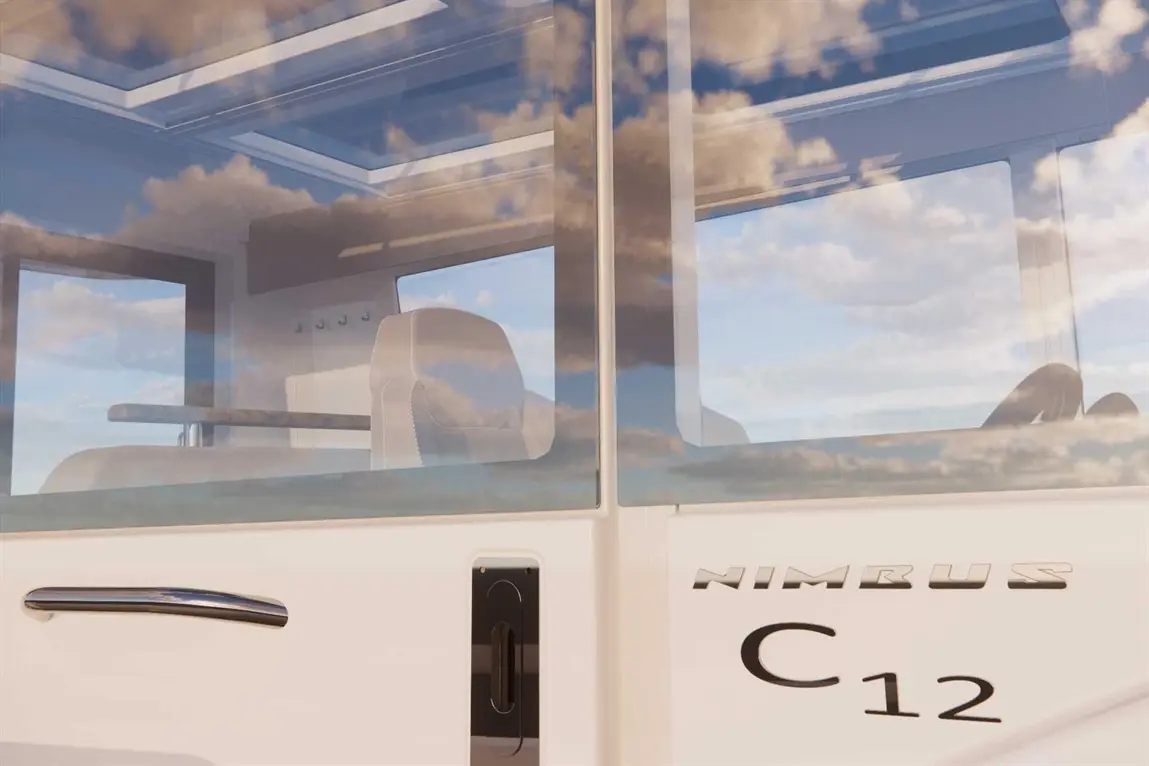 Interior of a Nimbus C12 vehicle with a sleek design, featuring white seats and large windows reflecting the sky.