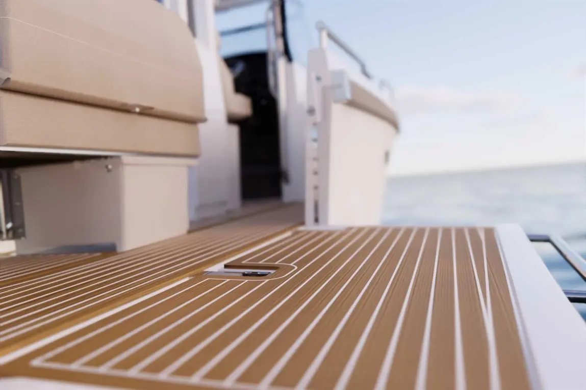 Close-up of a textured boat deck with wooden strips, leading to a boat interior against a serene sea background.