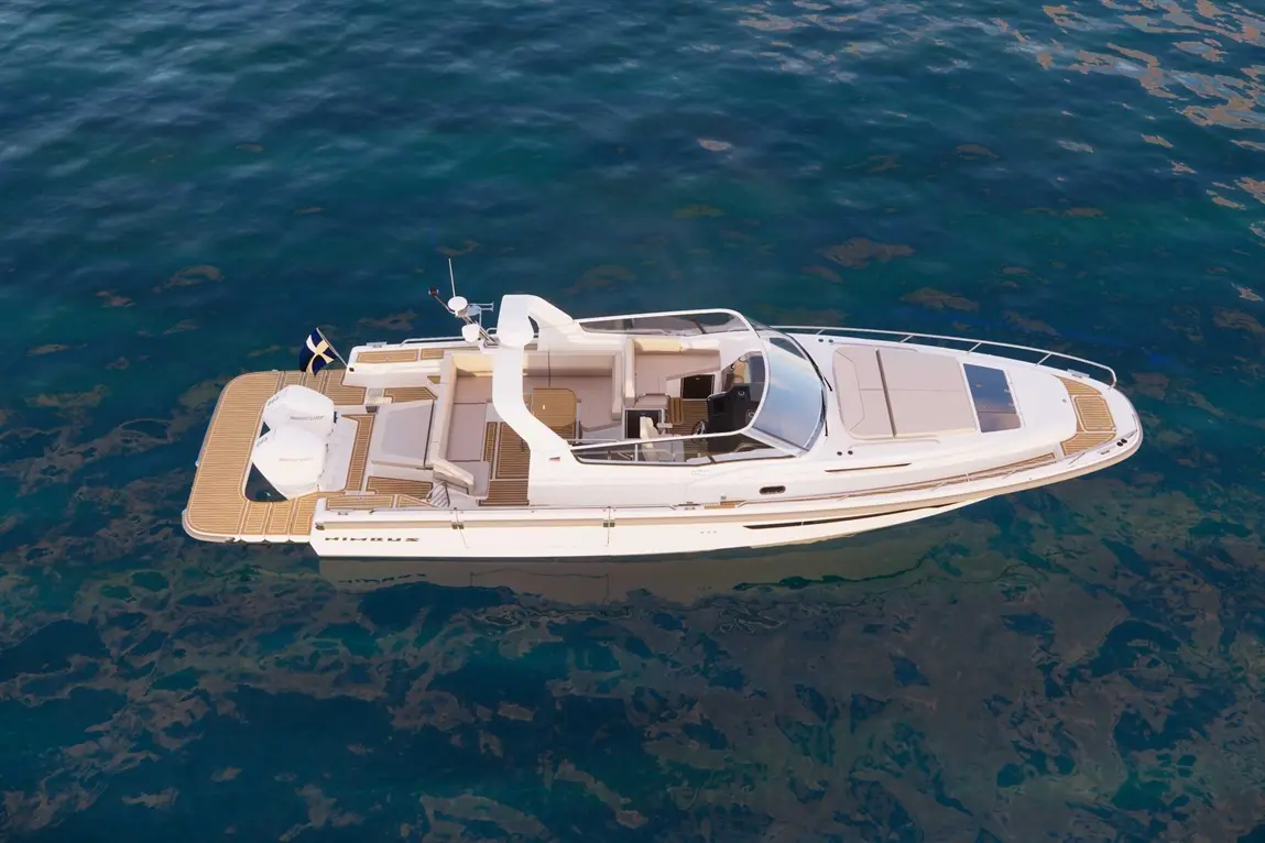 A luxury boat with seating, wooden decking, and engines is anchored in clear blue water, showcasing a serene marine environment.