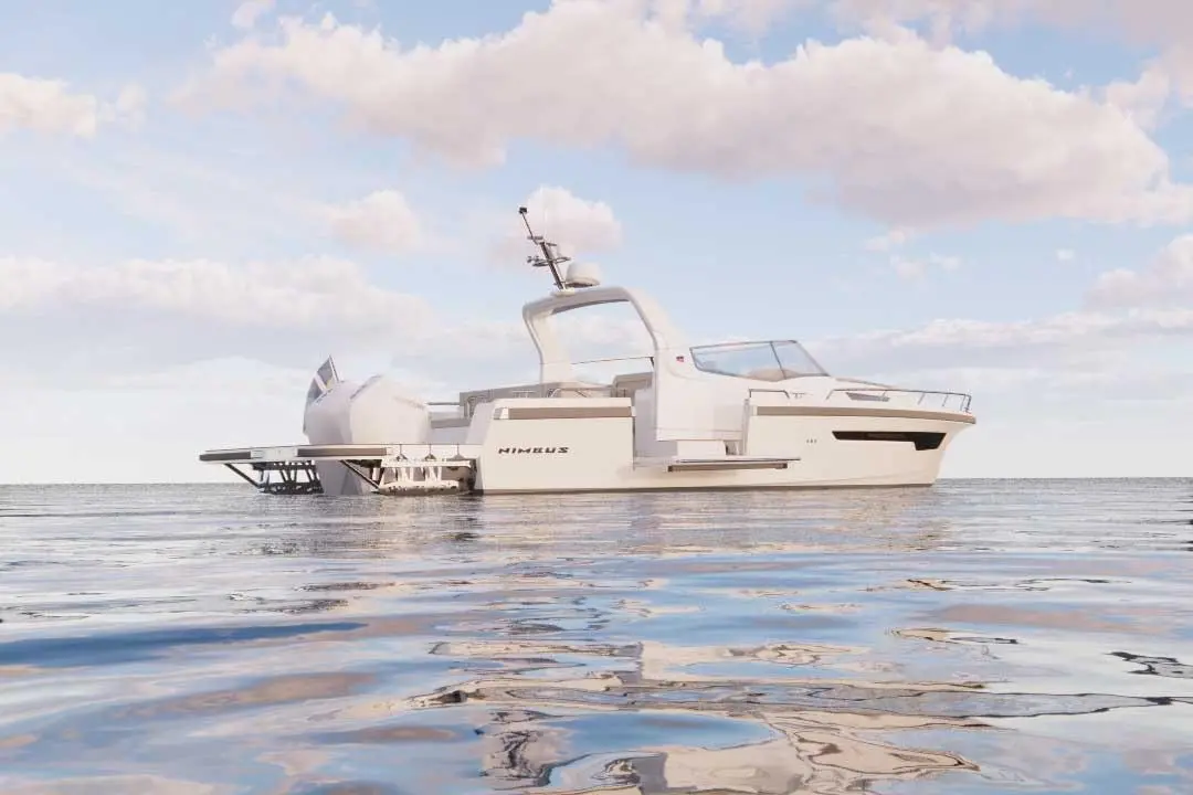 A sleek white boat named "NIMBUS" floats on calm waters under a clear sky with fluffy clouds.