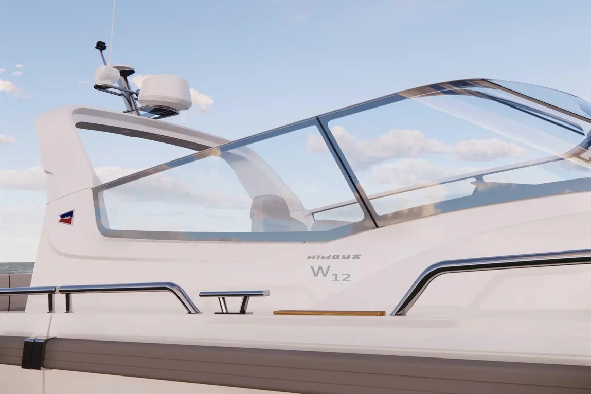A close-up of a Nimbus W12 boat showing its sleek design, window, and detailing on the side. Azure sky with clouds visible.