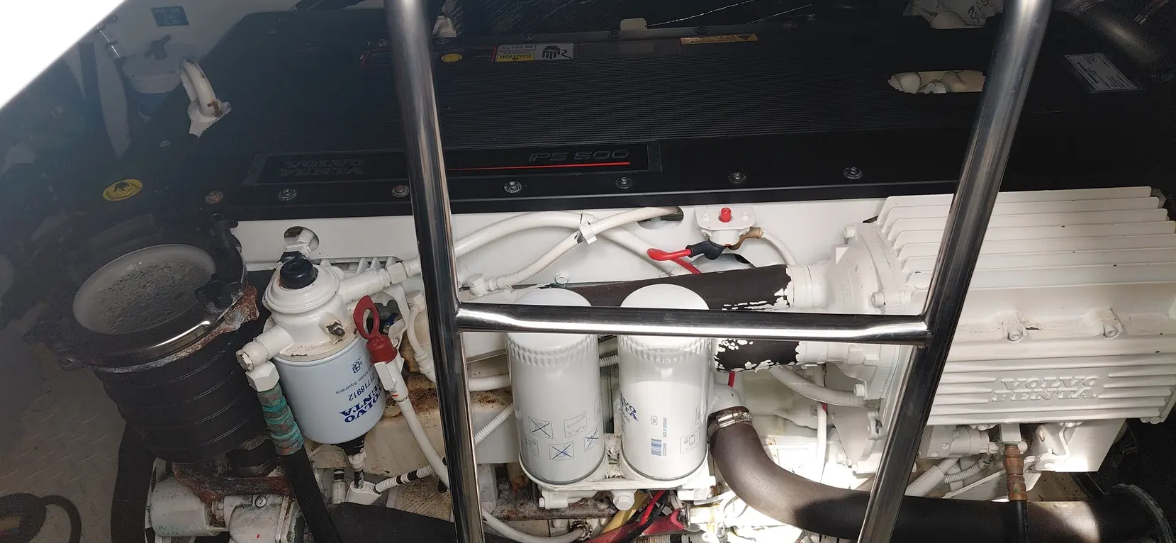 Volvo Penta IPS 500 engine compartment with filters, pipes, and a metal ladder visible in the frame.