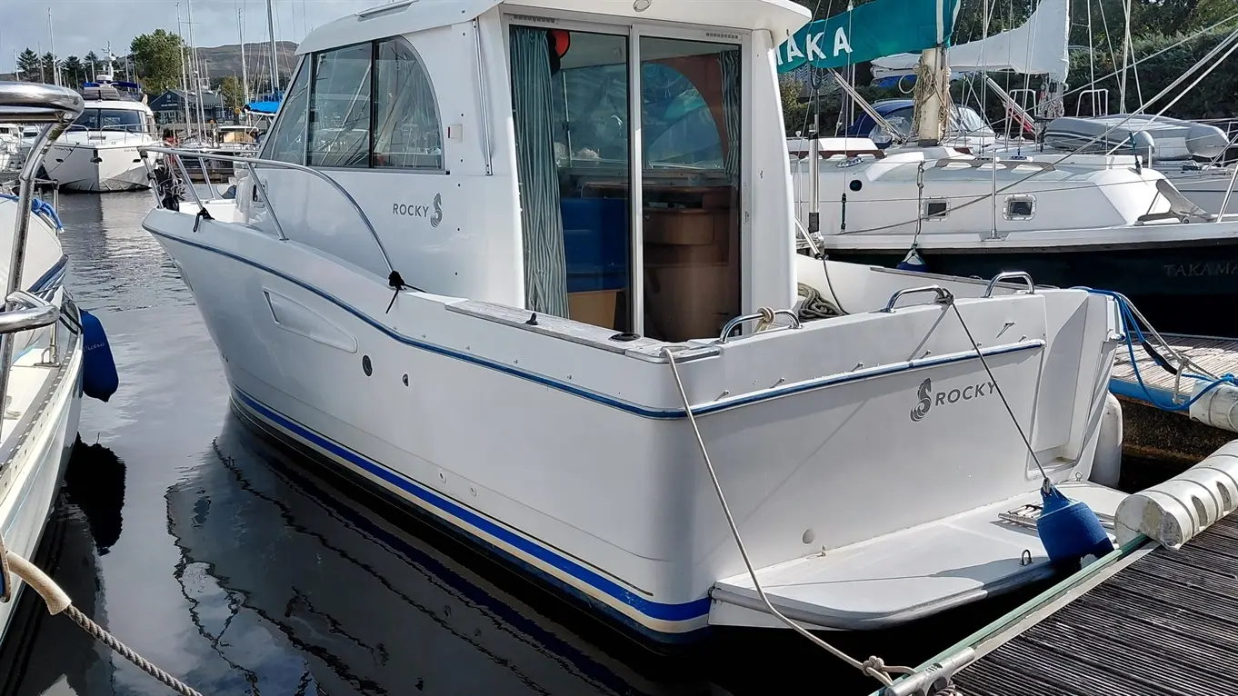 White Beneteau Antares 760 motorboat named “ROCKY” moored in a busy marina.