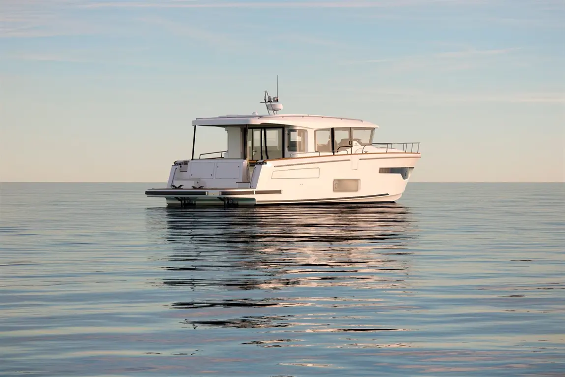 A sleek white motor yacht floats on a calm sea at sunset, reflecting light on the water's surface.