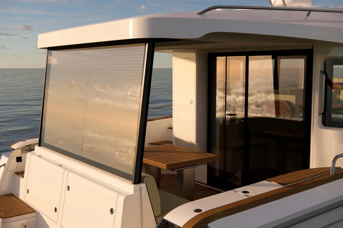 Stylish yacht cockpit with glass windows, wooden tables, and a serene sea view in the background during sunset.