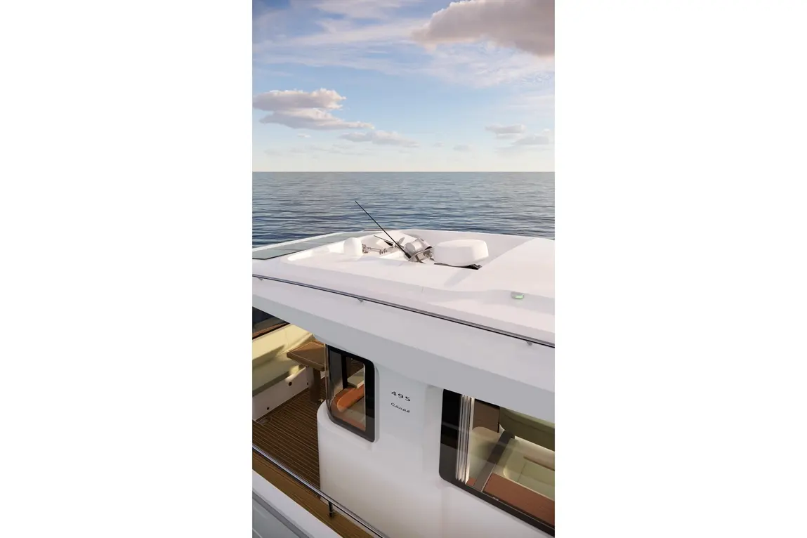 Top view of a modern yacht featuring a fishing rod holder, the number "495," and a calm sea under a blue sky with clouds.
