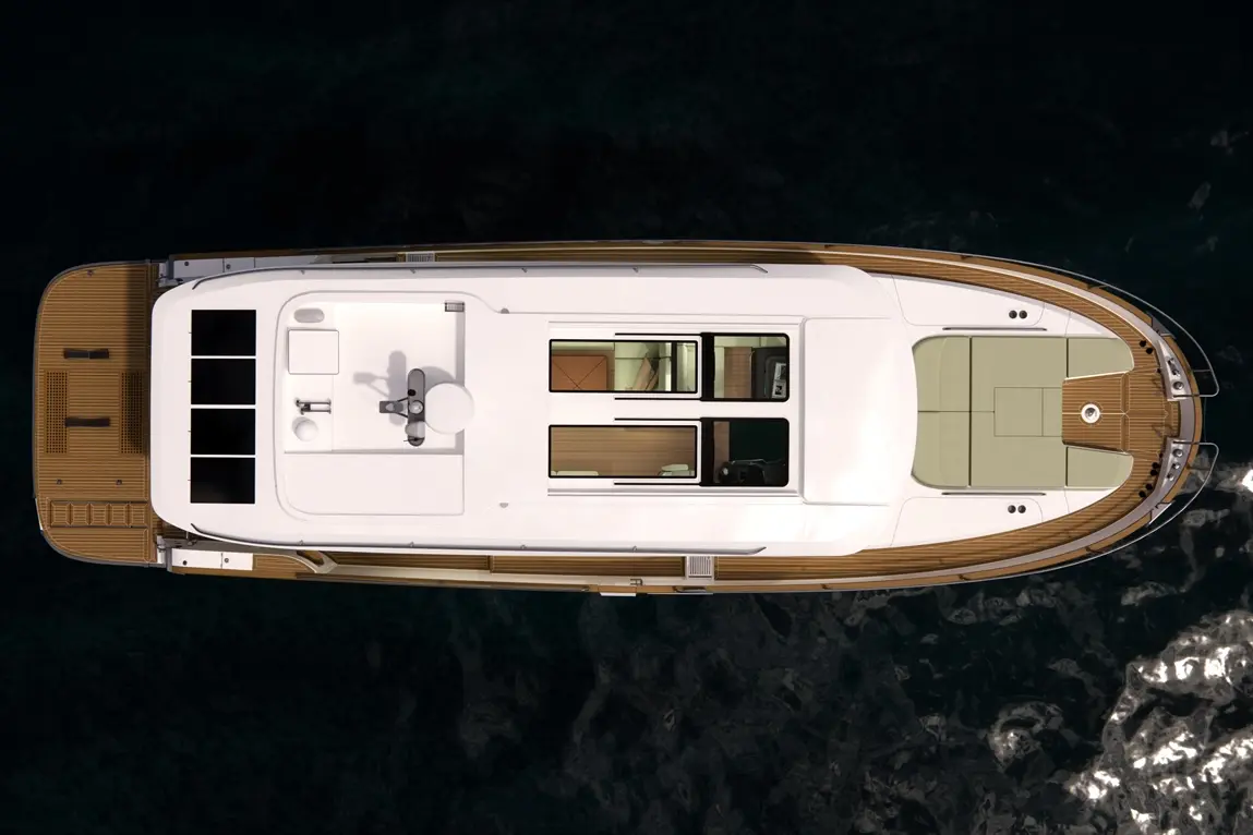 Bird's eye view of a luxury yacht featuring a spacious deck, helm, and cabin windows, set against dark water.