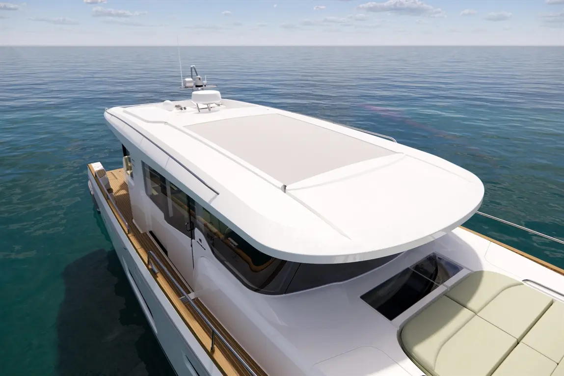 Luxury motor yacht deck with a sunshade and seating area, overlooking calm blue waters under a clear sky.