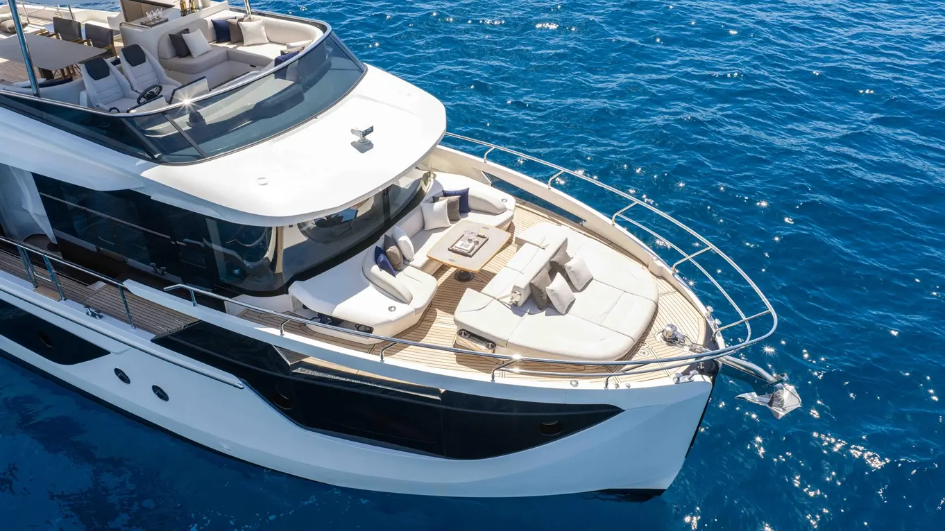 Luxury yacht with spacious seating on deck, overlooking sparkling blue water, perfect for relaxation or entertaining.
