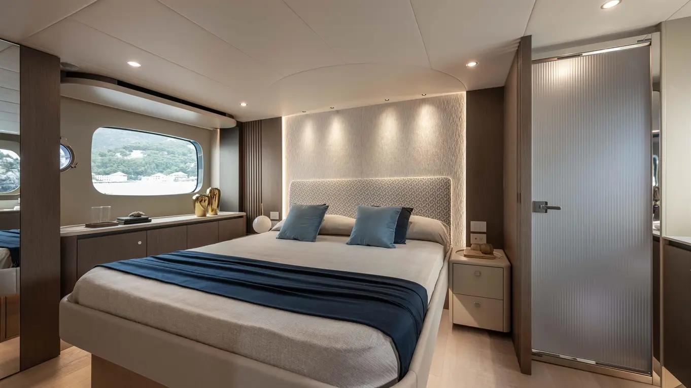 Modern yacht bedroom featuring a double bed, ambient lighting, stylish decor, and a large window with a scenic view.