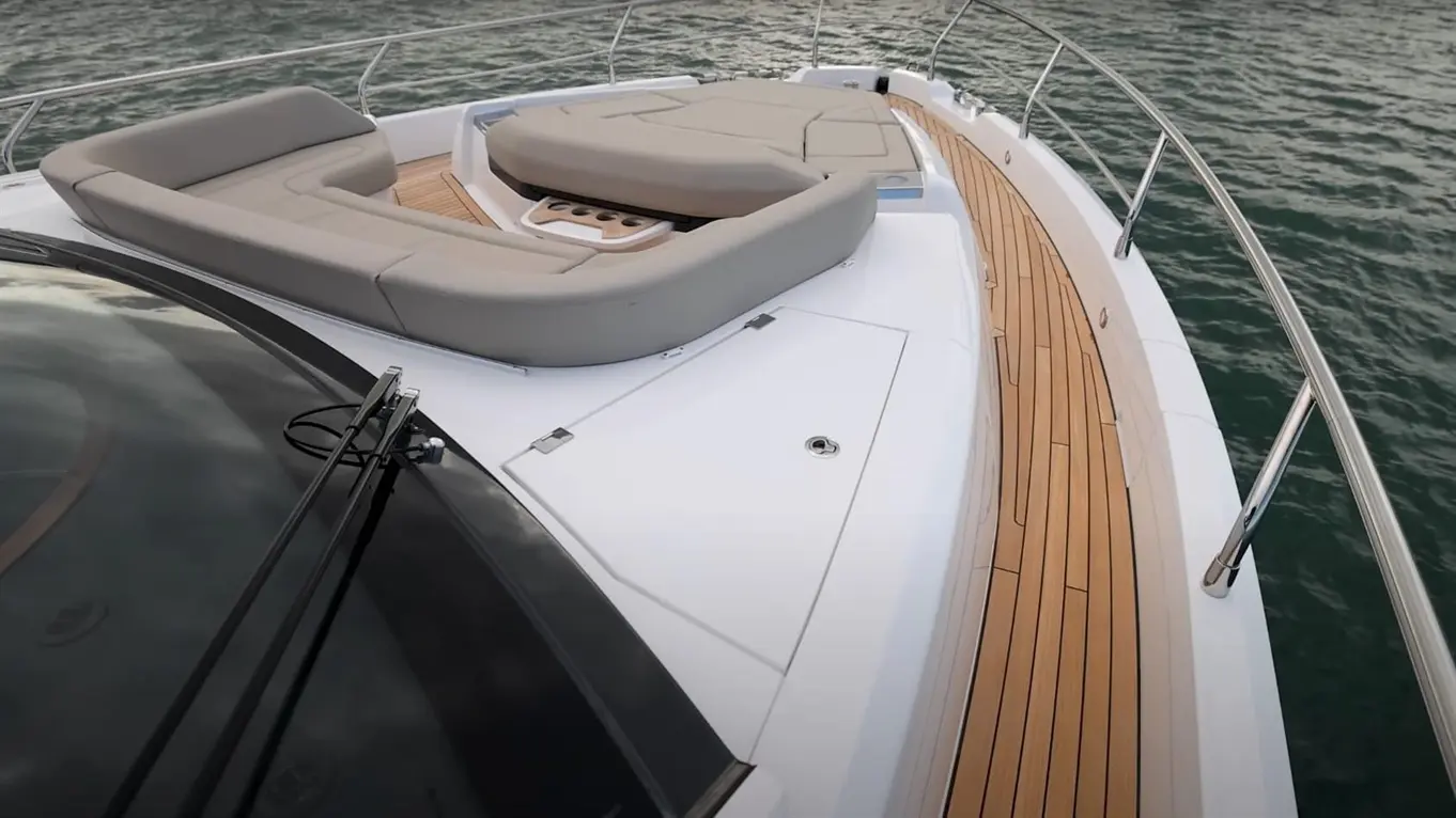 Luxury yacht deck featuring plush seating and wood detailing, overlooking the water for a relaxed outdoor experience.