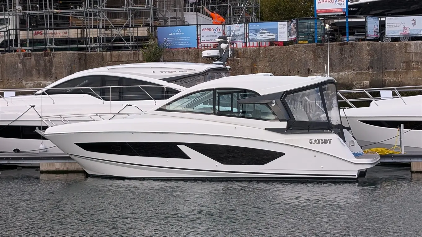 White Beneteau Gran Turismo 32 motor yacht, marked “TARGA 45”, moored at a marina.
