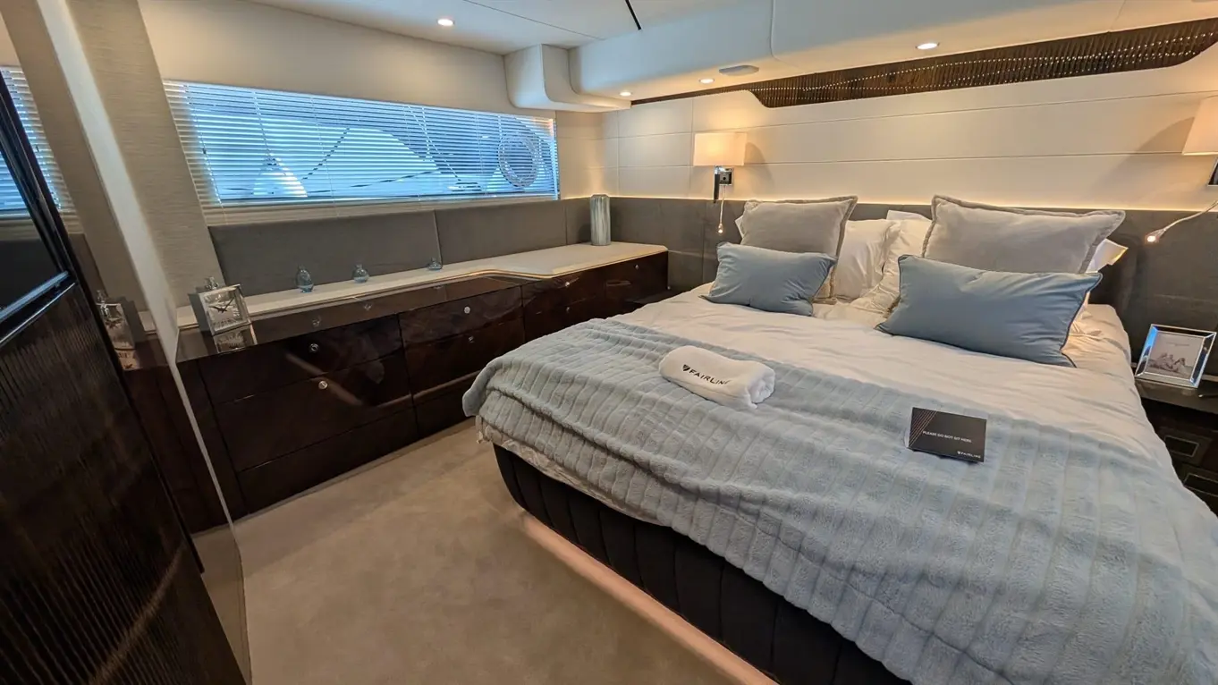 Luxurious bedroom featuring a double bed with plush cushions, stylish bedside lamps, and decorative drawers.