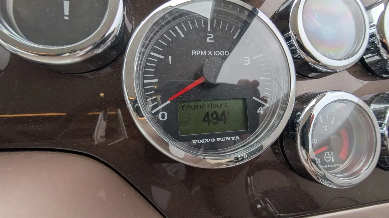 Volvo Penta dashboard showing an RPM gauge and engine hours display at 494h. Other gauges visible.